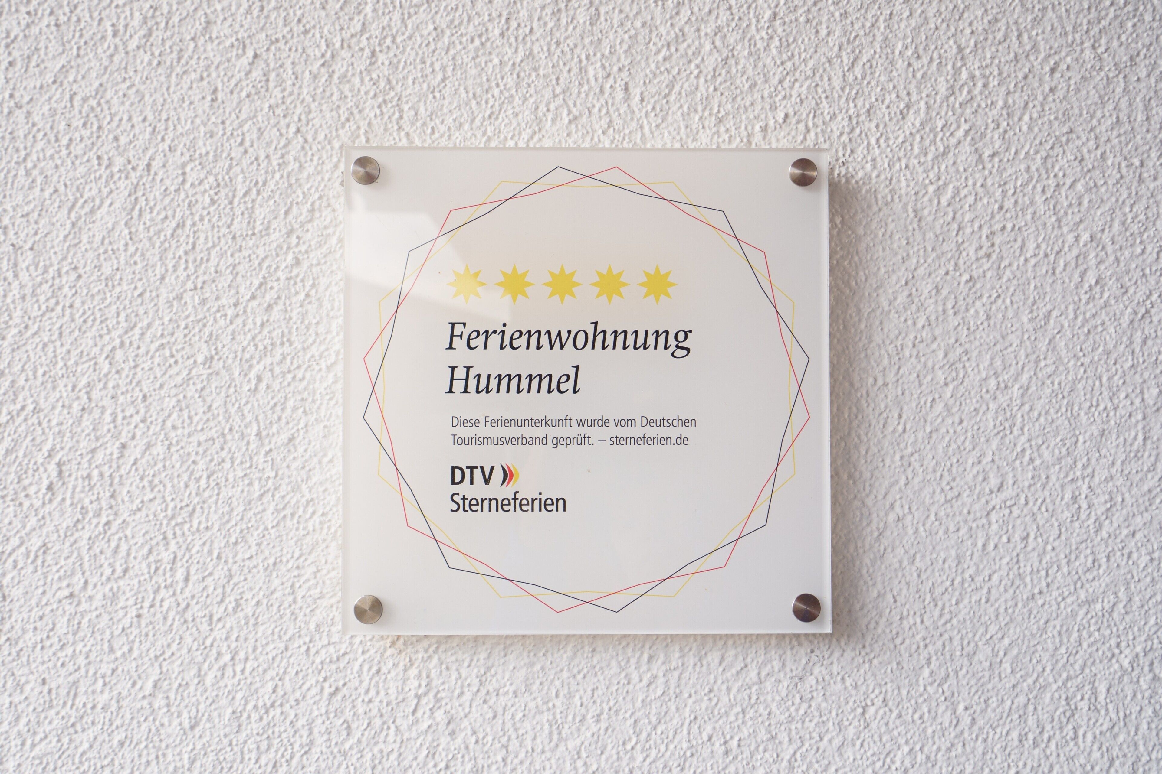 A sign with a hotel name, a description, and logos.