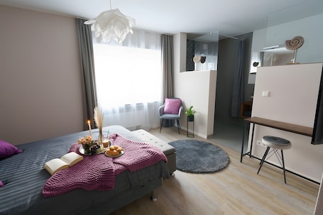 Una camera da letto moderna con un letto, un comodino e un piccolo angolo scrivania.. Appartamento '2' con terrazza privata, giardino in comune e Wi-Fi