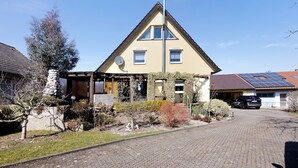 A house with a sloped roof, a chimney, and solar panels on the roof. - Apartment 'Honacker' with Private Terrace, Shared Garden and Wi-Fi (Steißlingen)