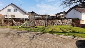 A residential area with houses, a paved driveway, and a playground. - Apartment 'Honacker' with Private Terrace, Shared Garden and Wi-Fi (Steißlingen)