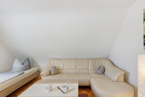 Una habitación con sofá, una mesa de centro y una lámpara.