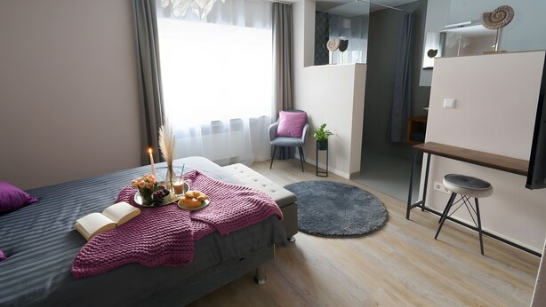 A modern bedroom with a bed, bedside table, and a small desk area. - Apartment '1' with Private Terrace, Shared Garden and Wi-Fi (Gammertingen)