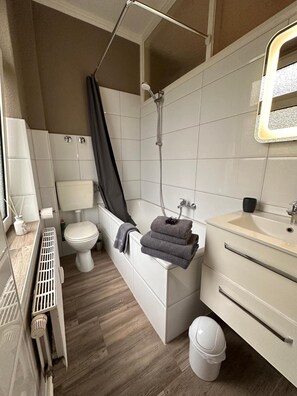 Un baño moderno con bañera, inodoro y lavabo.