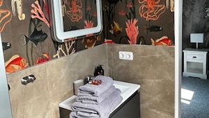 Une salle de bain avec un lavabo, un miroir et une pile de serviettes.