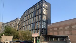 A modern building with a grid of windows and a sign indicating Baijiwan Lu.