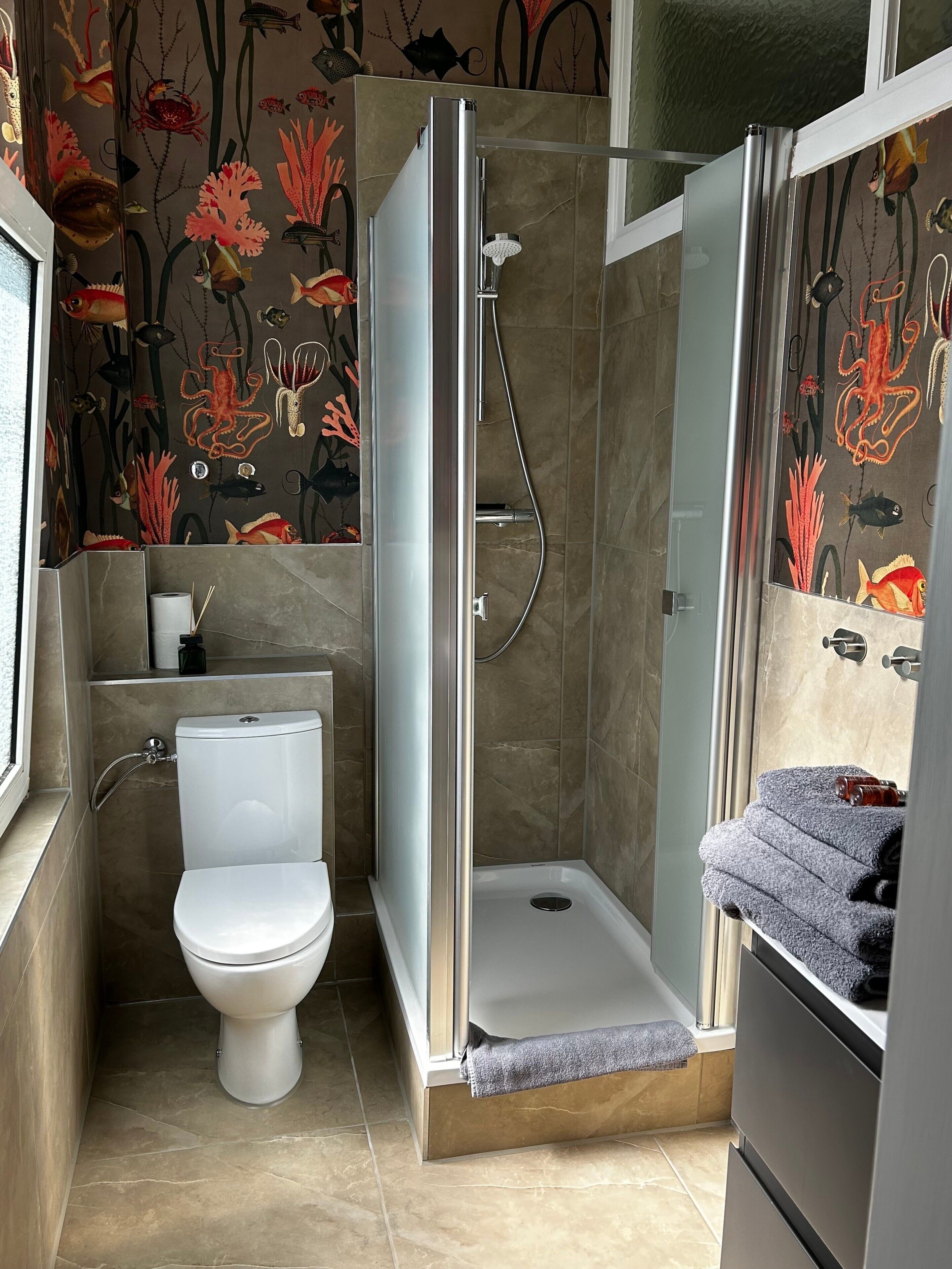 A bathroom with a toilet, a shower enclosure, and a towel rack.
