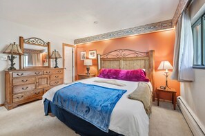 A bedroom with a wooden bed, a dresser, two bedside tables, and a mirror. - Cozy Mountain Get away (Copper Mountain)