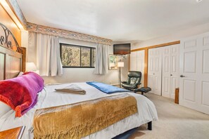 A bedroom with a bed, a chair, a window, and a door. - Cozy Mountain Get away (Copper Mountain)