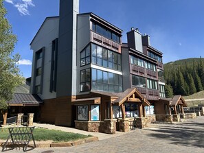 A modern multi-story building with large windows, stone foundations, and wooden accents. - Cozy Mountain Get away (Copper Mountain)