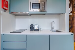 A kitchen with a built-in microwave, a coffee maker, and a sink. - City-center Apartment With Modern Comforts (Porto)