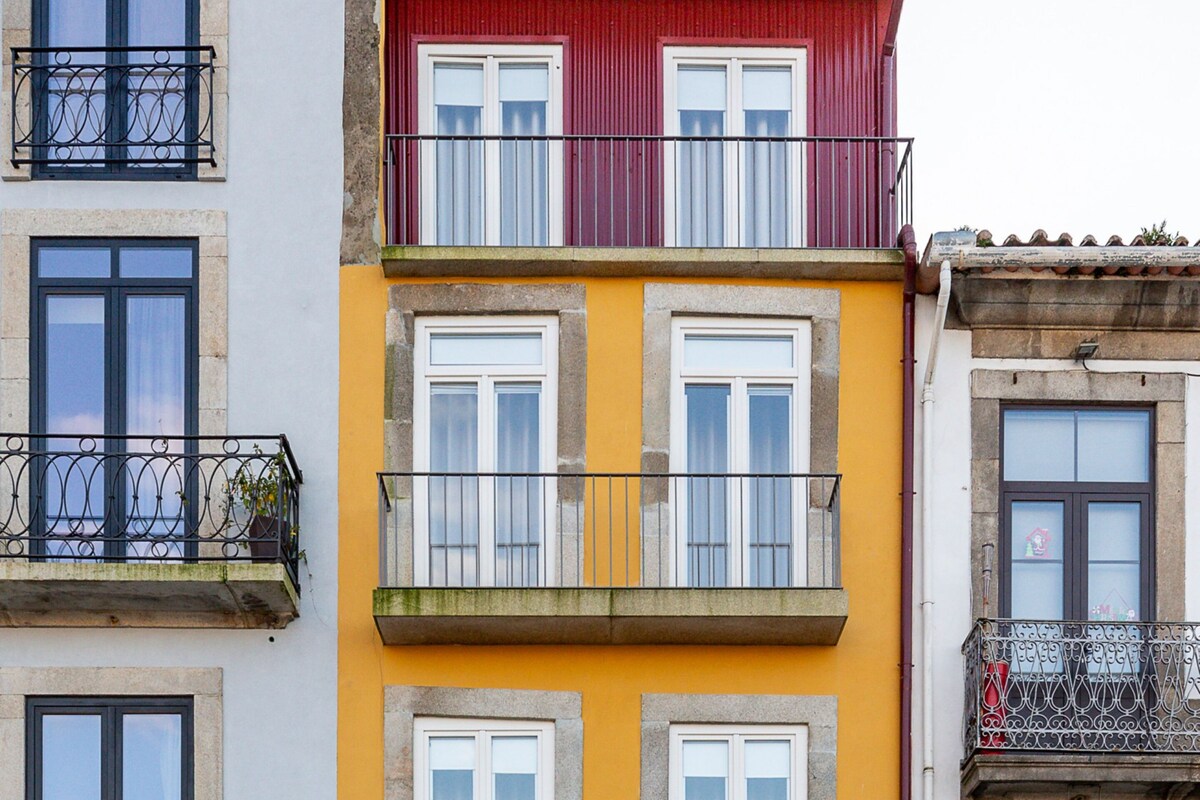 Un edificio a più piani con balconi, un negozio e il cartello di un ristorante.