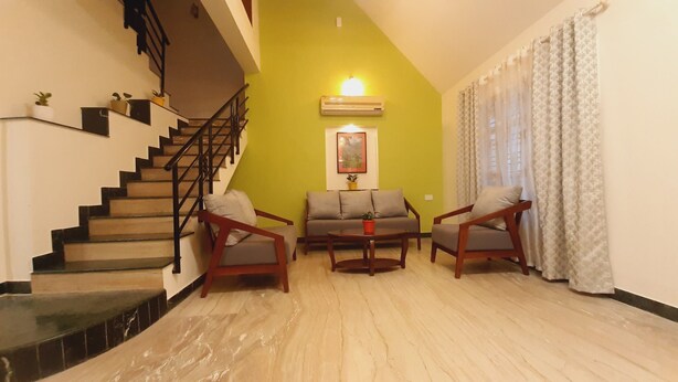 A living room with a staircase, a sofa set, and a coffee table.