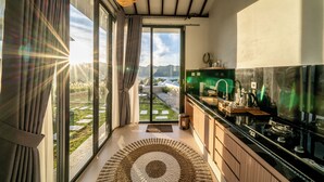 A modern kitchen with a large window, a view of the outdoors, and a dining area.