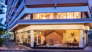 A Vivit Hostel in Bangkok with a modern design, featuring a brick facade and large windows. - Lamoon Vivit (Bangkok)