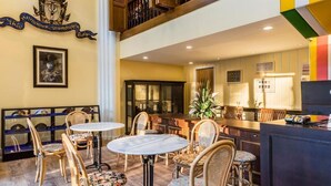 A hotel lobby with a bar area, seating with wicker chairs, a large decorative wall piece, and a framed picture on the wall. - Lamoon Vivit (Bangkok)