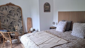 A bedroom with a bed, a chair, a mirror, a lamp, and a wall-mounted picture. - B&B Baie du Mont Saint-Michel (Le Val-Saint-Père)