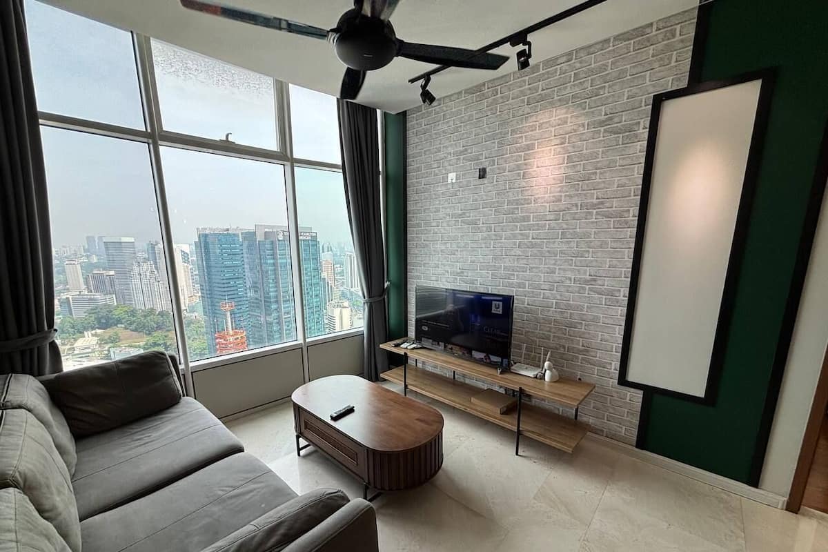 A modern living room with a large window, a flat-screen TV, a sofa, and a coffee table.