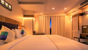 A hotel room with a large bed, a desk, and a chair. - Hotel Mandovin - A Premium Hotel In Udaipur (Udaipur)