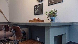 Un pequeño espacio de cocina moderno con encimera de madera, una cafetera y una planta en maceta.