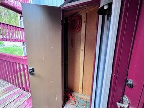 A wooden door with a metal handle, a red cable, and a wooden floor.