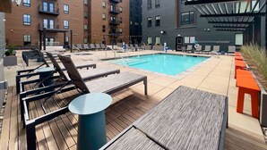Área de piscina no terraço com espreguiçadeiras e piscina.