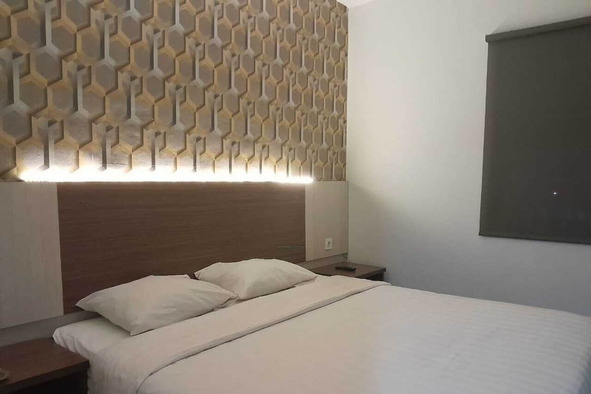 A neatly made bed with white linens, a wooden headboard, and a wall with a geometric pattern.