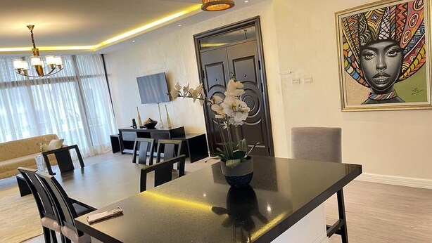 A modern dining area with a black countertop, white cabinets, and a chandelier. - Luxurious 3-bedroom apartment with WiFi in Bole Addis (Addis)