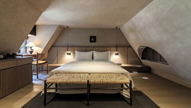 A modern bedroom with a large bed, bedside tables, a small desk, and a window. - ANMO Hotle (Xiamen)