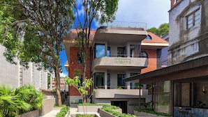 A modern building with a courtyard featuring planters and seating. - ANMO Hotle (Xiamen)