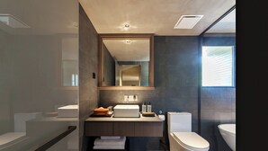 A modern bathroom with a large mirror, a sink, a toilet, and a shower area. - ANMO Hotle (Xiamen)