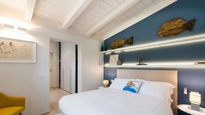 Una camera da letto moderna con un letto, una sedia gialla, una parete blu decorata con pesci e un soffitto bianco.