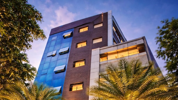A modern building with a sign for 'Diamond Palace' indicating it offers various room types. - Diamond palace (bengalore)