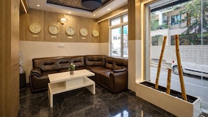 A modern lobby with a leather sofa, a coffee table, and a decorative plant. - Diamond palace (bengalore)