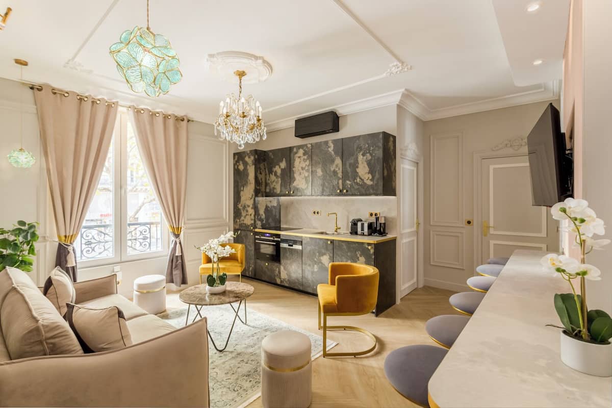A modern living room with a sofa, a round coffee table, and a bar area with bar stools.