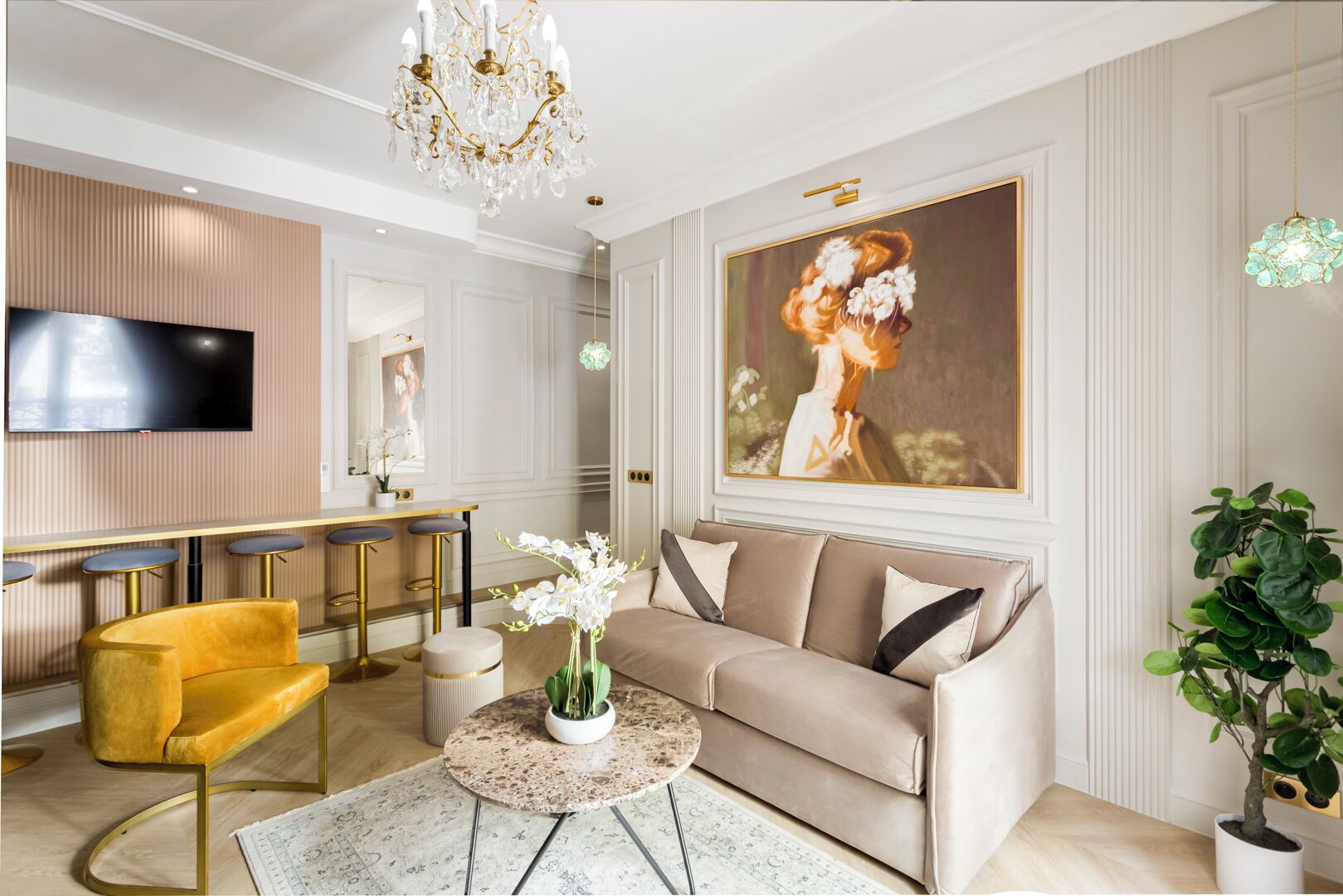A modern living room with a beige sofa, a round coffee table, a yellow armchair, and a TV mounted on the wall.