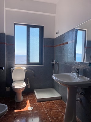 Habitación triple, vistas al mar | Baño | Ducha, artículos de higiene personal gratuitos, secador de pelo y bidé