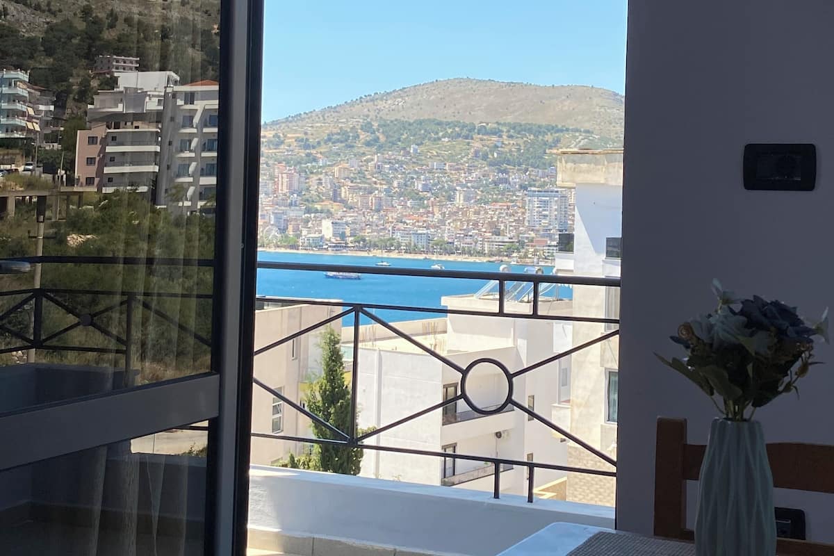 A balcony with a view of a cityscape and a body of water.