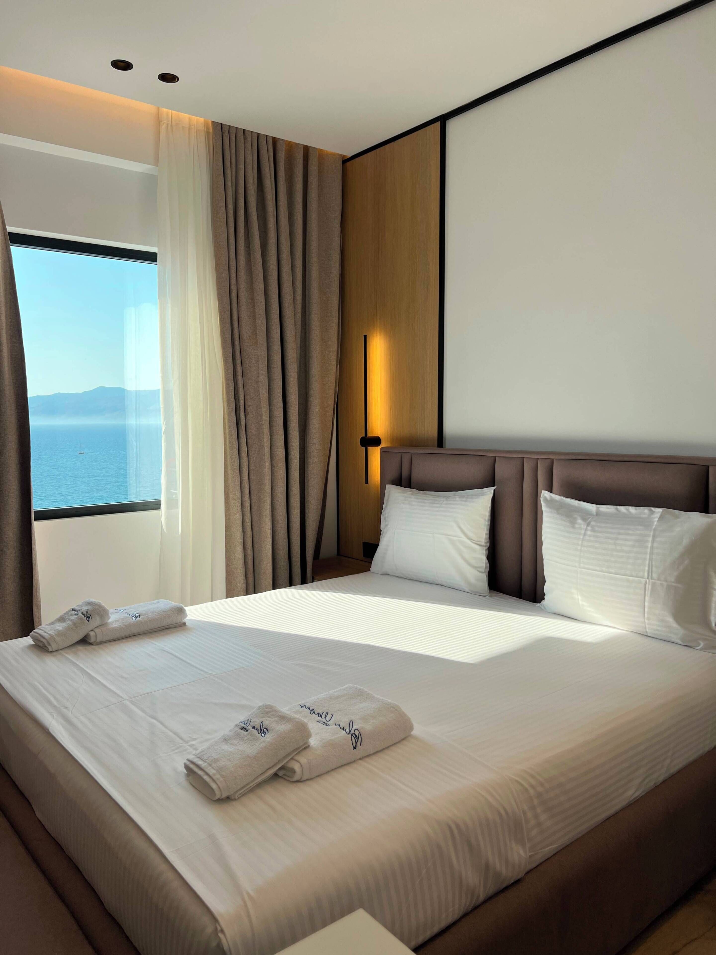 Een hotelkamer met een groot bed, uitzicht op zee en een modern design.