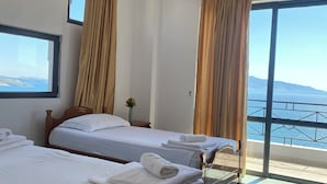 A hotel room with two beds, a large window, and a view of the sea. - Blue Waves Hotel & Suites (Sarandë)