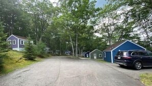 A residential street with houses and a parked car. - Happy Cottage Near Everything 11 (Edgecomb)