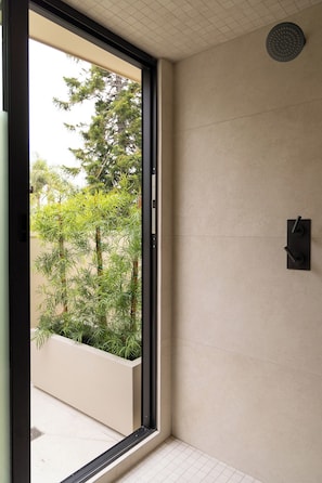 Ein modernes Badezimmer mit einem großen Fenster, einer Duschbrause und einem Handtuchhalter.