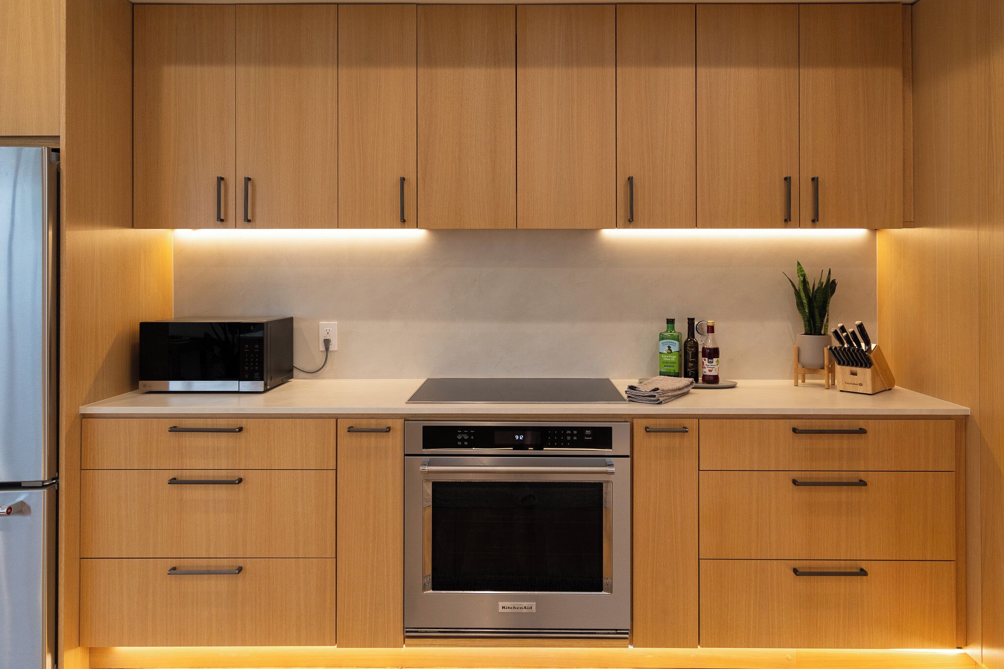 Una cocina moderna con armarios de madera, microondas integrado, estufa y lavaplatos.