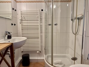 A modern bathroom with a glass-enclosed shower, a white sink, and a towel rack. - Seaside - Central 2-room app. for 2-4 pers. with balcony and WLAN (Sylt)