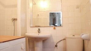 A bathroom with a sink, mirror, shower, and toilet. - El patio de Tarifa . (Tarifa)