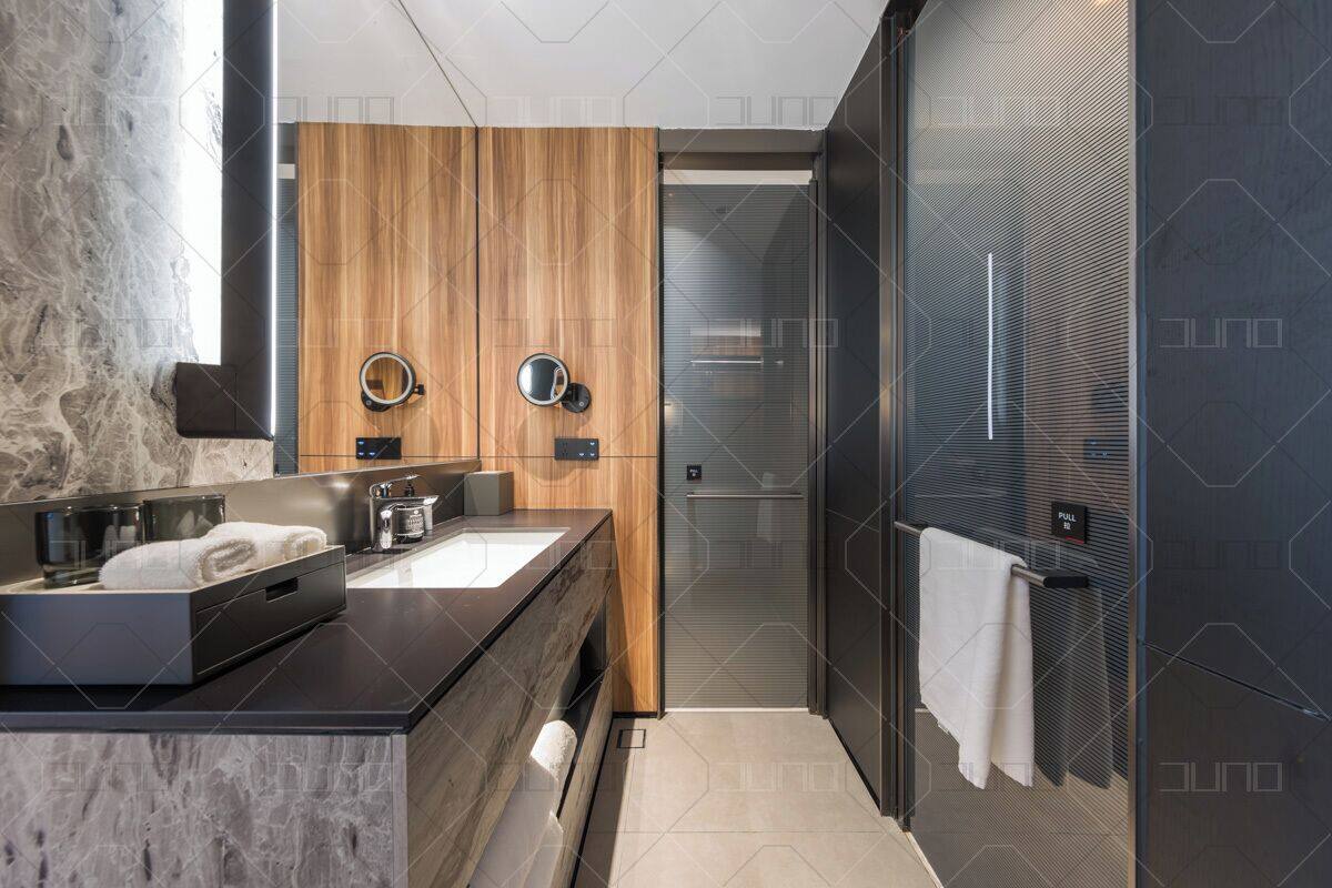 Une salle de bain moderne avec un meuble-lavabo en bois, deux vasques, un miroir et une cabine de douche en verre.