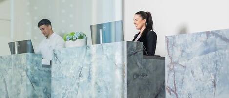 A reception area with marble counters and a potted plant.