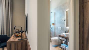 Een moderne badkamer met douche, toilet en wastafel.
