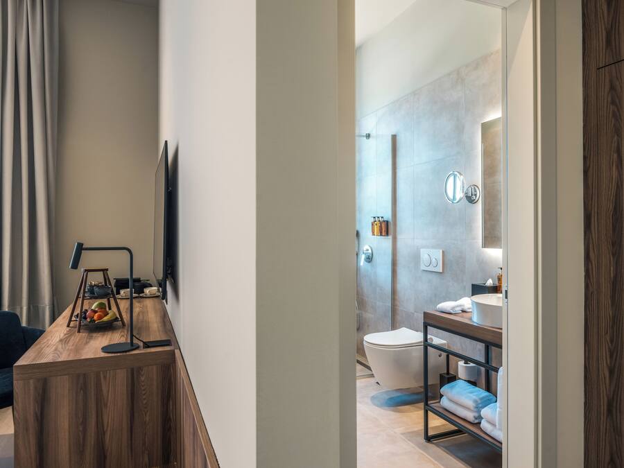 Een moderne badkamer met douche, toilet en wastafel.