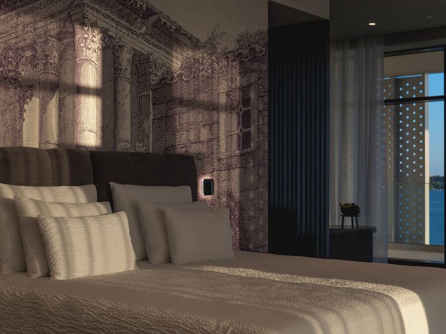 Un dormitorio moderno con una cama grande, un mural en la pared y vistas al agua.