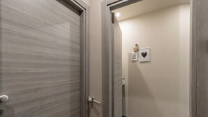 A hallway with a wooden door, a framed picture, and a heart-shaped decoration on the wall. - Cerisola lovely studios in Rapallo (Rapallo)